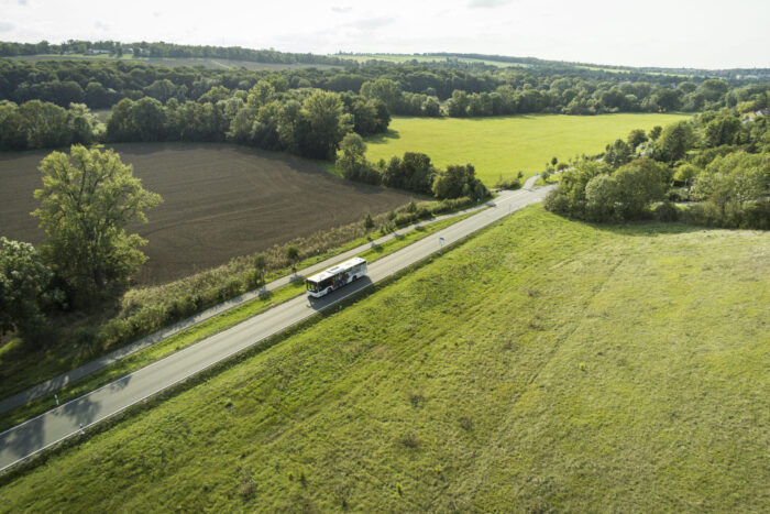 Luftaufnahme eines Busses in grüner Landschaft